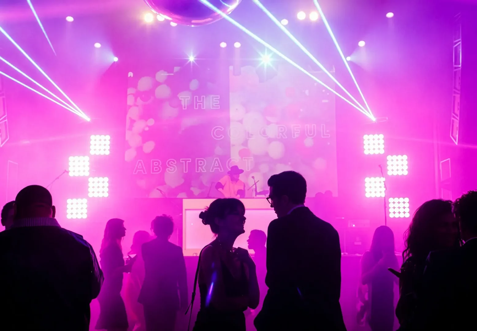 Colorful party with DJ, lights, fog, and dancing crowd.