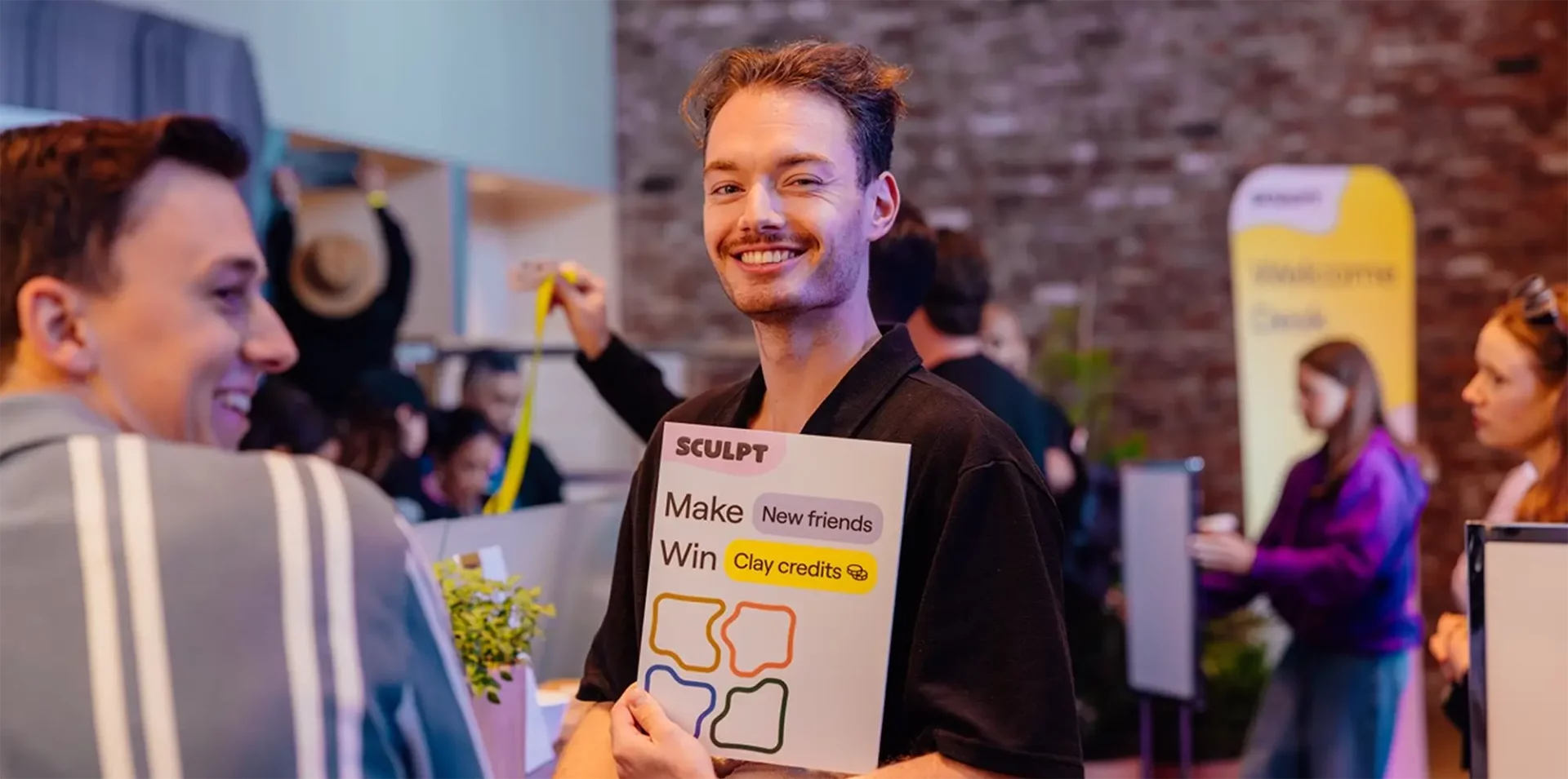 Guest smiling while holding SCULPT sign